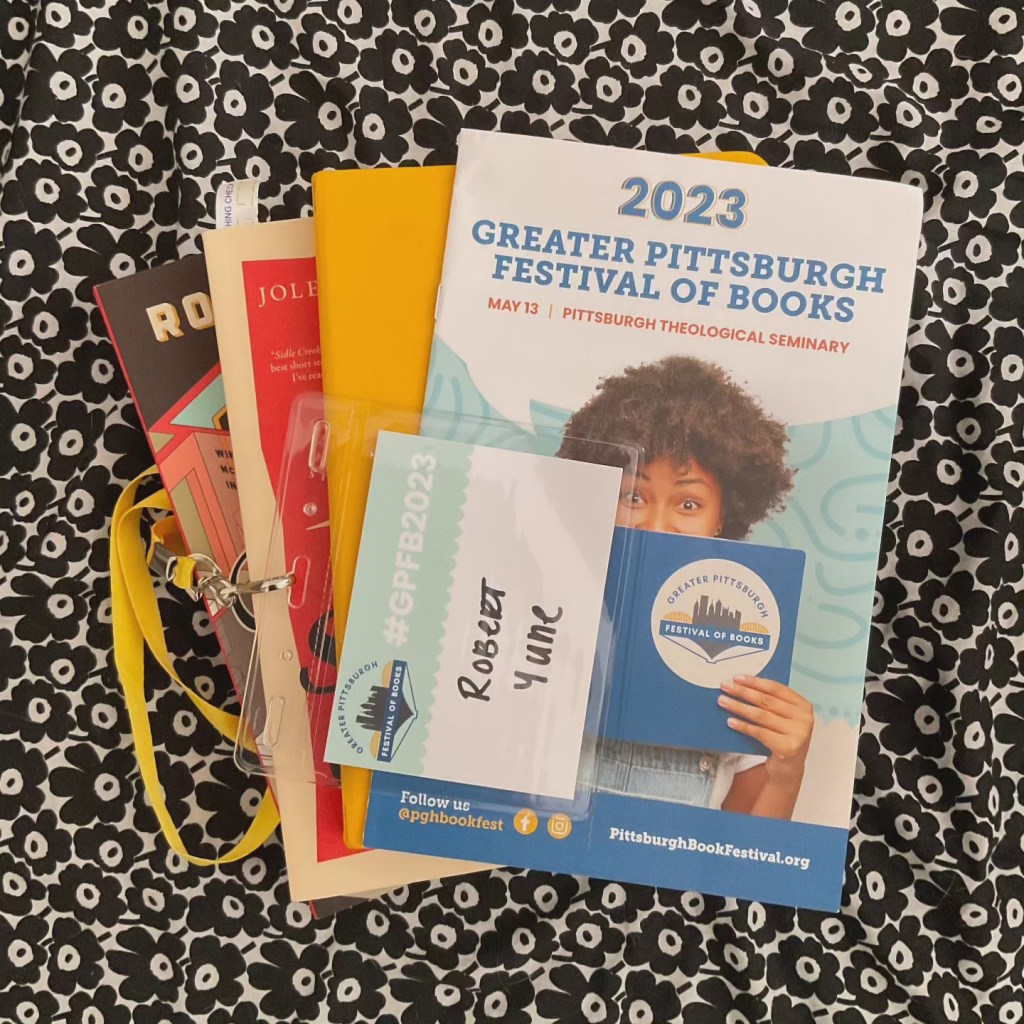 A flyer for the 2023 Greater Pittsburgh Festival of Books, along with Jolene McIlwain's book and a name badge for the festival