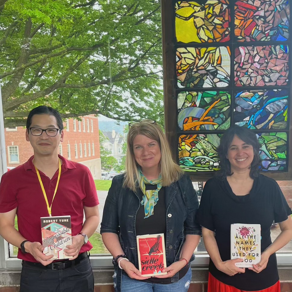 A shot of the three panelists, each holding a copy of their respective book